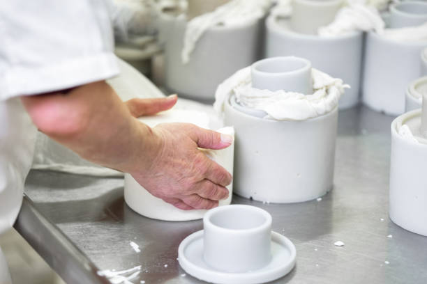 istock Cheese production industry. workers close up preparing cheese raw dough into molds. 1149308633