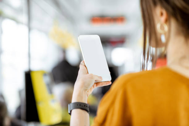 donna con telefono ai mezzi pubblici - bus inside of people train foto e immagini stock