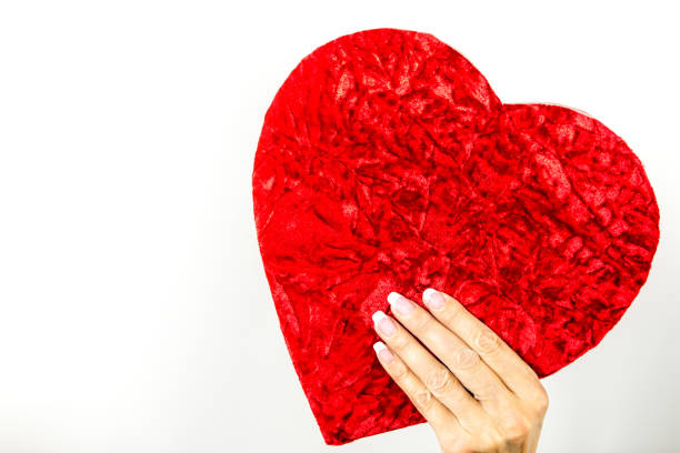 istock Woman is holding a heart shaped gift box 1149315942