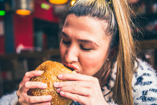 istock Woman Eating Delicious Burger 1149322174