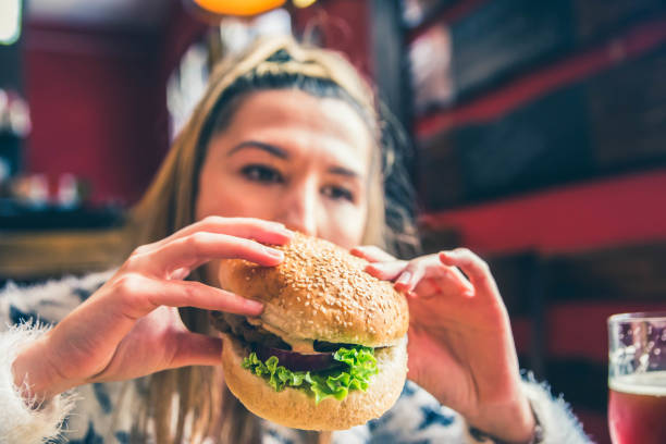 istock Woman Eating Delicious Burger 1149322533