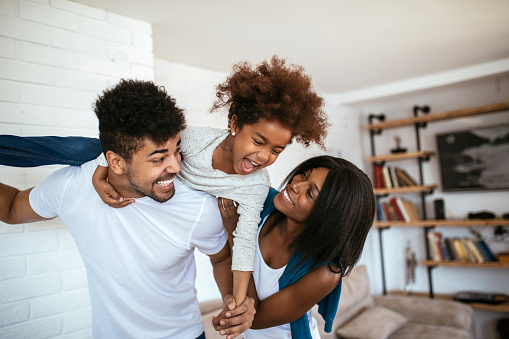 Shot of happy african american family having fun together at home.
