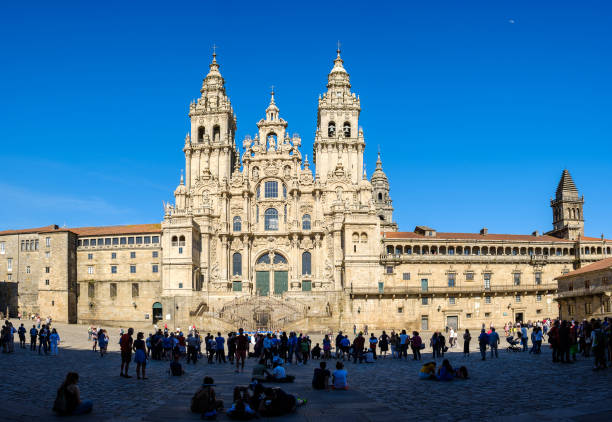 Santiago de Compostela , Spain - May 12, 2019: Tourists and pilgrims roam the streets where magnificent buildings are situated in the historic Spanish city, Santiago de Compostela, Spain.