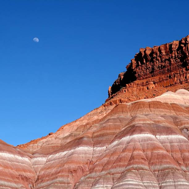 Multi rock layered canyon and moon in the sky at daytime