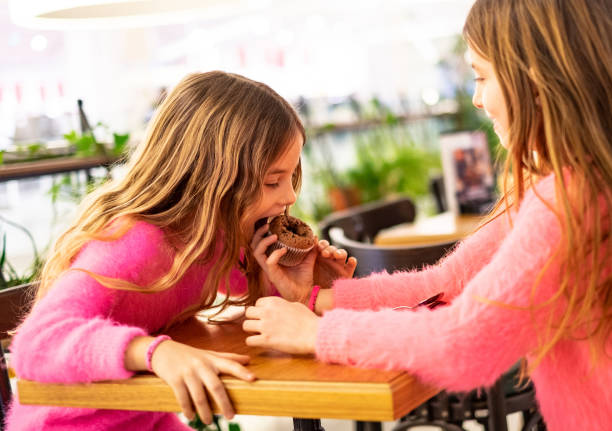 istock Two cute girls sharing one cake 1149325155