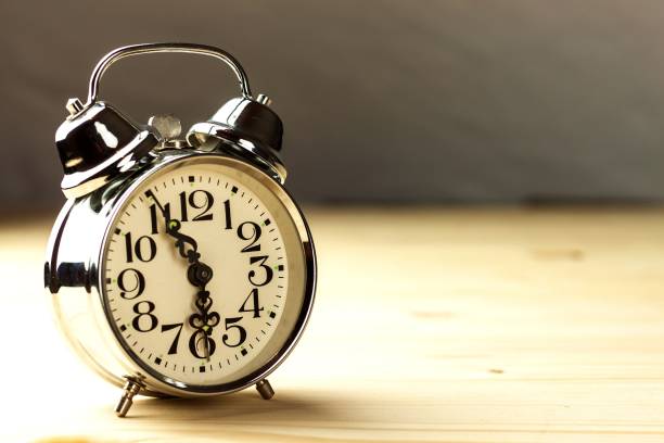 istock Retro alarm clock on table. Concept of getting up to work. Morning awakening. 1149327043