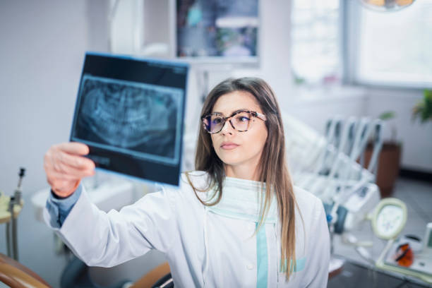istock Female dentist looking at dental x-ray 1149328359