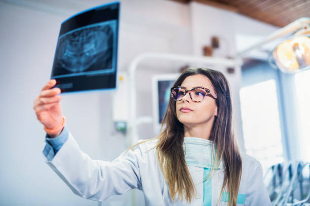 istock Female dentist looking at dental x-ray 1149328361