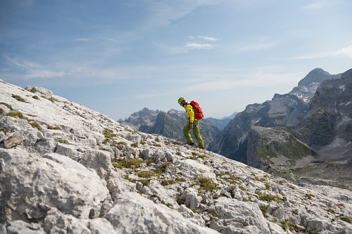 One person in a wast land of mountains. Moving up the mountain to the top. Nice day in european alps.