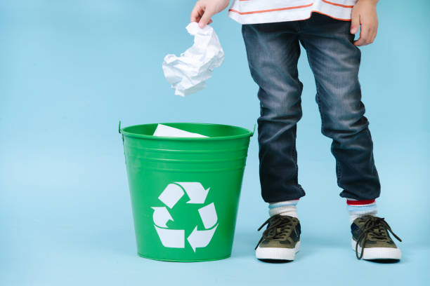 istock Child is throwing crumpled paper in recycling bin. 1149330656