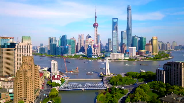 Aerial view of skyscraper and high-rise office buildings in Shanghai Downtown with Huangpu River, China. Financial district and business centers in smart city in Asia at noon with blue sky.