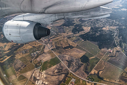Jet Engine over agricultural landscape photographed trough airplane window