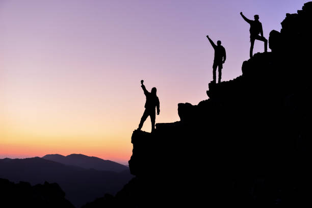 istock successful people on the peaks of mountains 1149335497