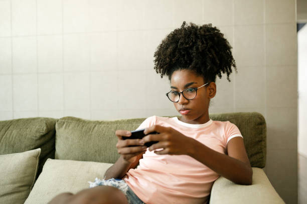 電話でビデオを見て十代の少女 - gamer video game video computer ストックフォトと画像