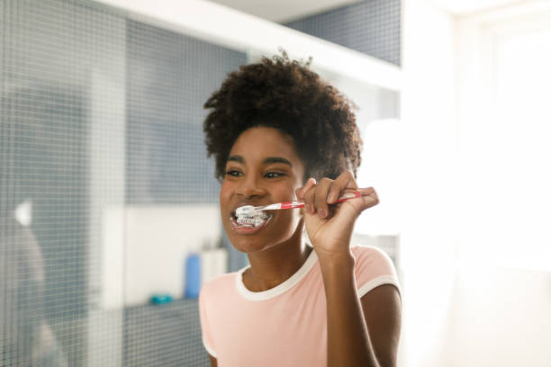 Teenage girl brushing her teeth