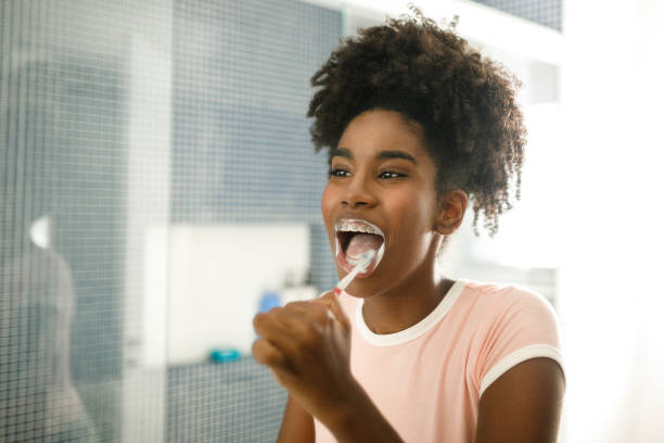 istock Teenage girl brushing her teeth 1149335843