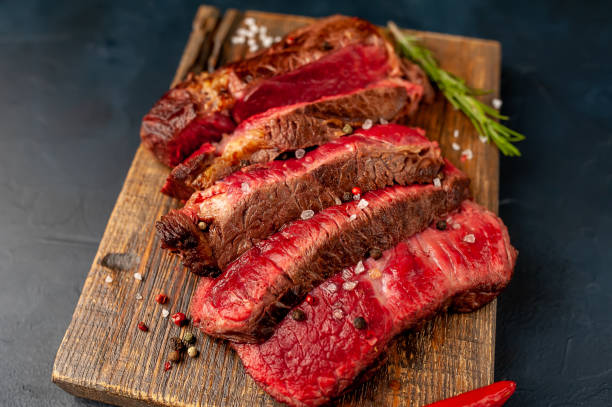 istock Grilled rib eye beef steak with herbs and spices on a stone background 1149337434