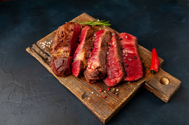 istock Grilled rib eye beef steak with herbs and spices on a stone background 1149337439