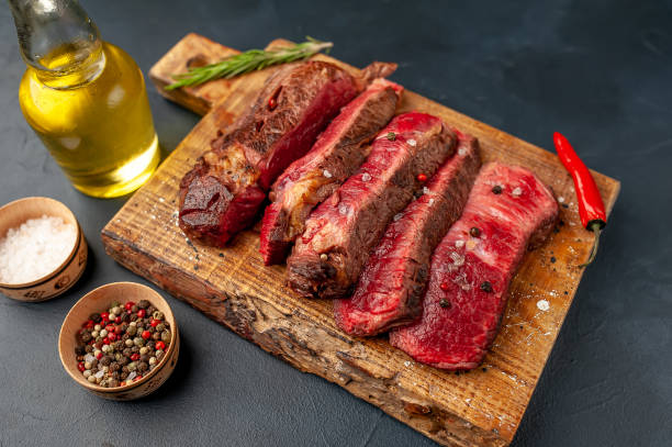 istock Grilled rib eye beef steak with herbs and spices on a stone background 1149337520