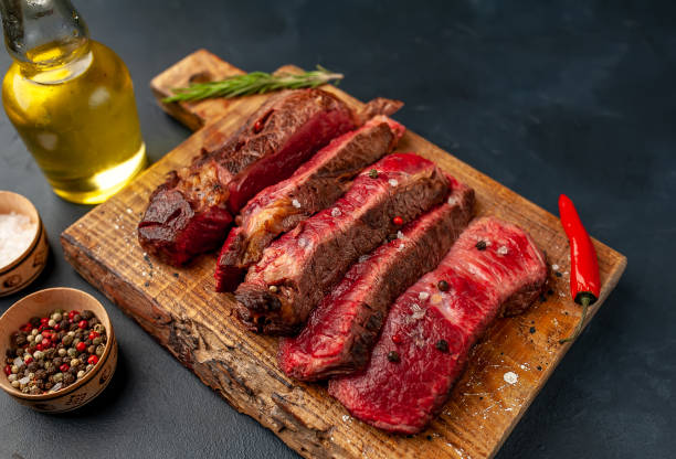 istock Grilled rib eye beef steak with herbs and spices on a stone background 1149337526