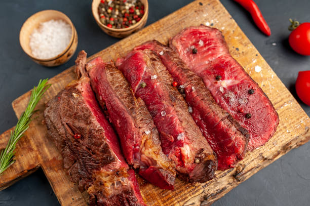 istock Grilled rib eye beef steak with herbs and spices on a stone background 1149337581