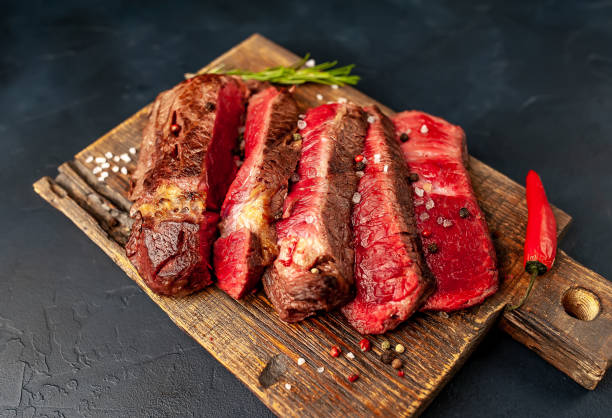 istock Grilled rib eye beef steak with herbs and spices on a stone background 1149337659