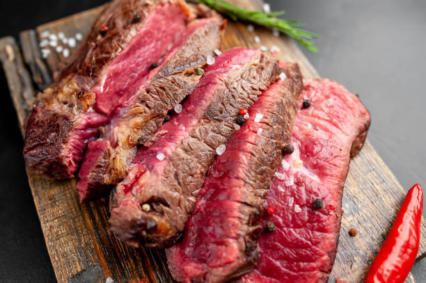 istock Grilled rib eye beef steak with herbs and spices on a stone background 1149337824