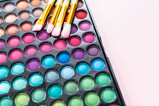 istock New eyeshadow palette with makeup brushes on a pink background. 1149338119
