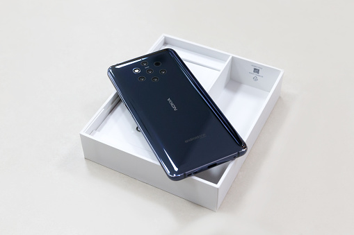 Belgrade, Serbia - May 08, 2019: New Nokia 9 Pure View mobile smartphone is displayed from rear side on cardboard box. Flagship gadget on isolated white background.