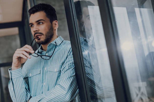 istock Pensive young bearded man with glasses indoors 1149340762