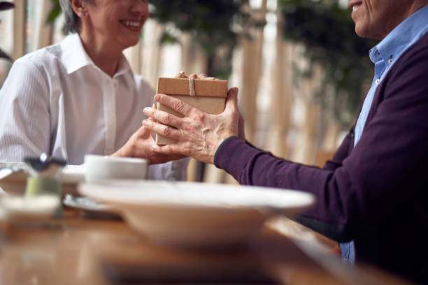 istock Aged man giving present box to happy lady 1149343899