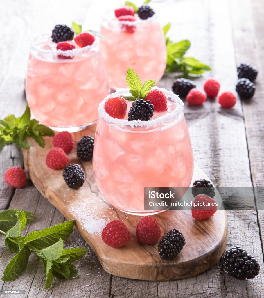 Pink Summer Drinks Three pink refreshing summer fruit drinks with fresh fruit salt rim Cocktail Stock Photo