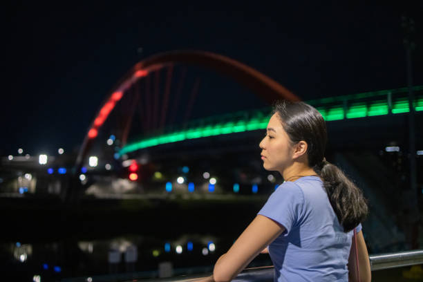 Young woman relaxing at river side at night