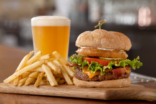 onion burger fries and a beer on a bar top