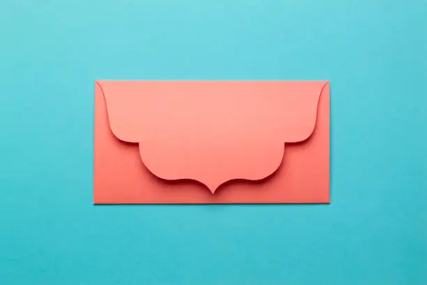 Photo of The orange envelope on turquoise paper background.