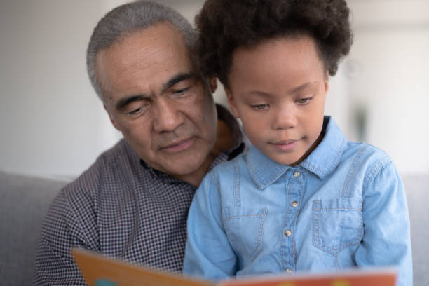 istock Black Grandpa Reading With Granddaughter 1149368551