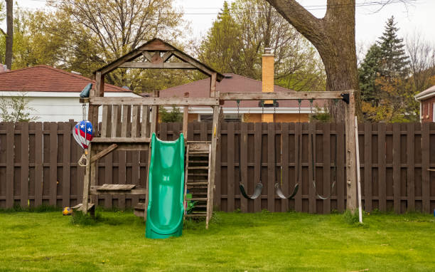 Swing set in backyard during spring season with lush grassy lawn Swing set in backyard during spring season with lush grassy lawn jungle gym stock pictures, royalty-free photos & images
