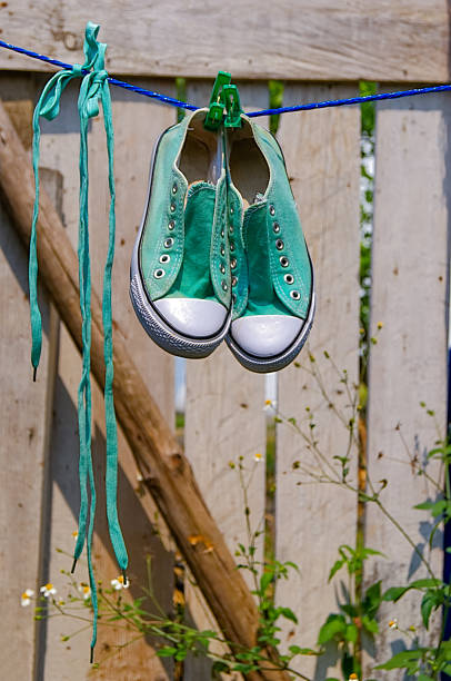 istock pair of green and blue sneakers hanging 1149370940