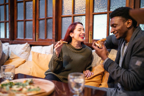 istock Multi-ethnic couple enjoying pizza in a cafe 1149384065