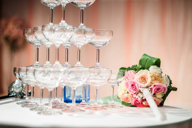 A lot of champagne glasses in a row with bouquet