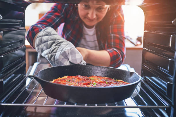 istock Preparing Pizza in a Cooking Pan with Tomato Sauce and Mozzarella 1149396530