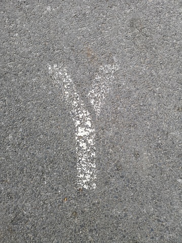 The letter Y has been stenciled on a gray asphalt background with space all around for other graphic elements