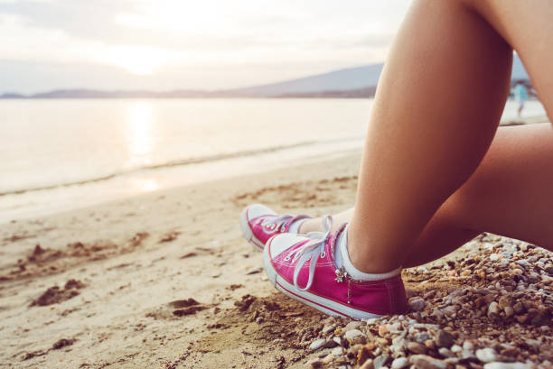 istock Female legs sunbathing on the beach 1149404175