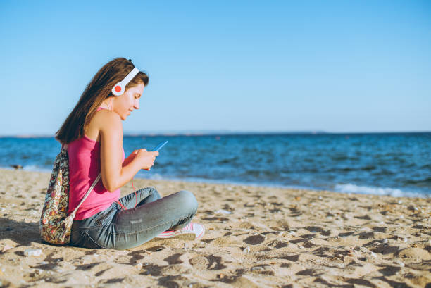 istock Woman using phone on the beach 1149405900