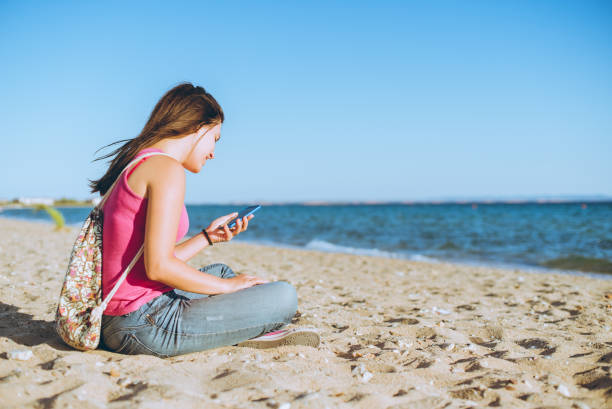 istock Woman using phone on the beach 1149405910