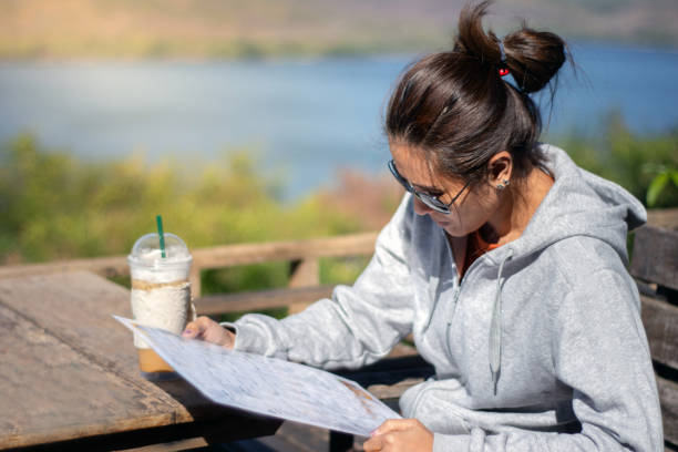 istock Asian beautiful woman reading menu at restaurant with coffee cup on the table 1149409115