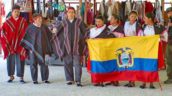 Indigenous dancers holding the Ecuadorian flag at the train station in Sibambe, on the Devil's Nose Railroad