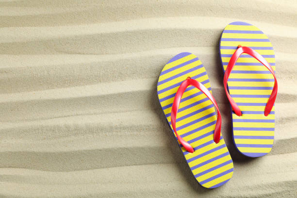 istock Clear sea sand with flip flops, space for text and top view. Summer vacation background 1149415913