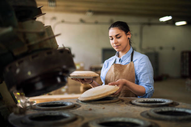 Woman Prepare the machine for preparing ceramic plates.