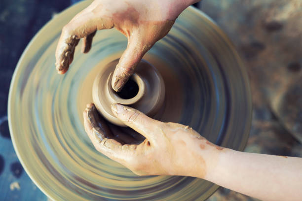 陶器のホイールで働く女性の手のクローズアップ。 - shaping clay ストックフォトと画像